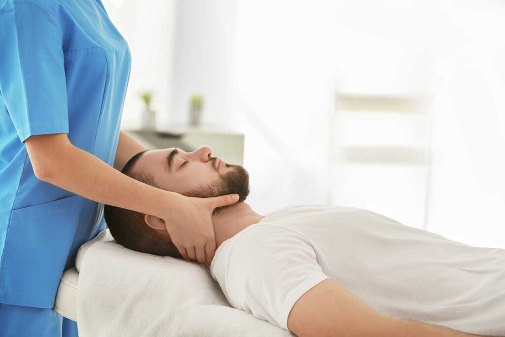 Athlete receiving a controlled back adjustment while discussing movement with a clinician.